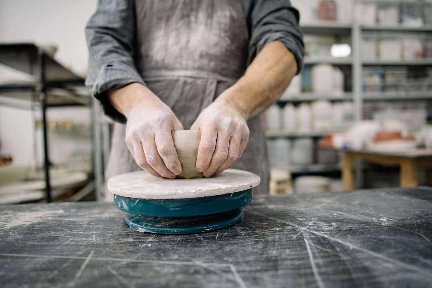 Een pottenbakker werkt aan een schaal op de draaischijf