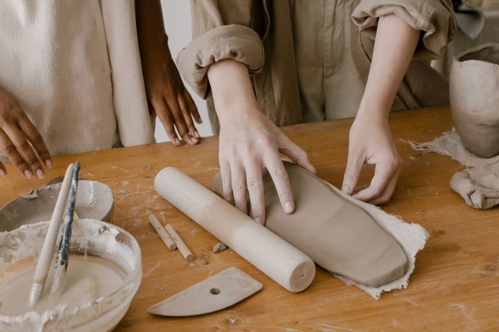 Deelnemers werken met klei tijdens een keramiekworkshop