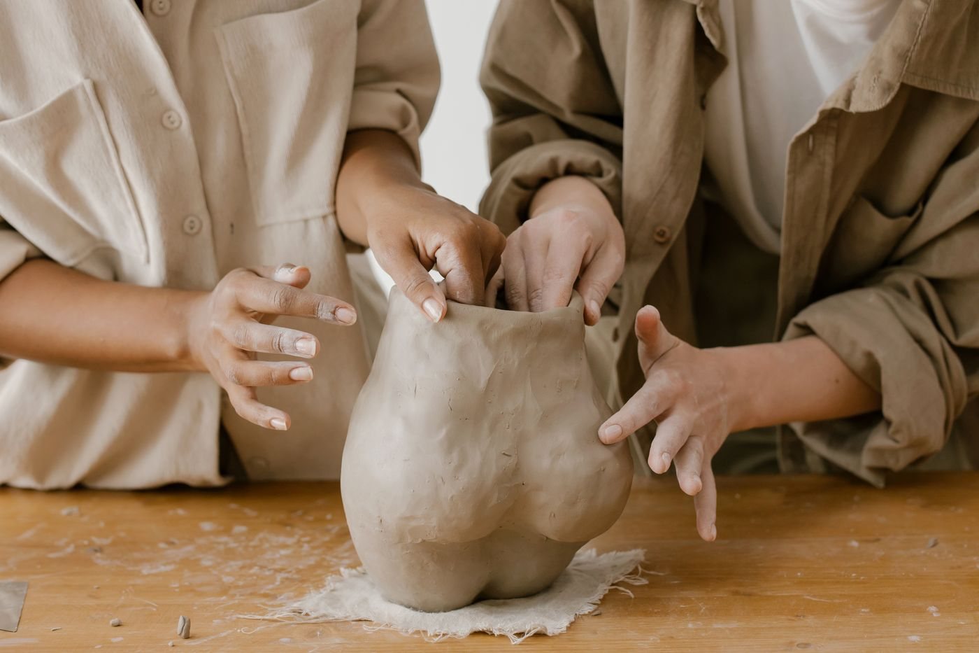 Samen een vorm van klei maken aan een houten tafel